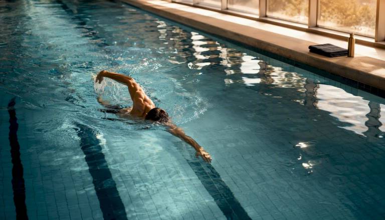 Person schwimmt entspannt eine Bahn im Schwimmbecken