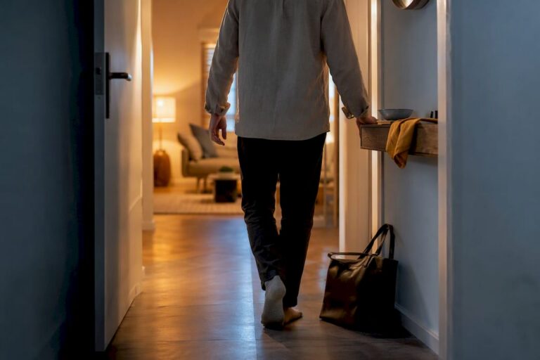 Person legt die Arbeitstasche im Flur ab