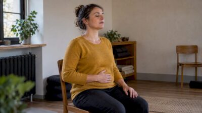 Frau übt im Kursraum eine ruhige Bauchatmung